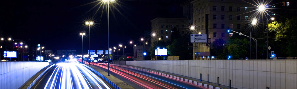 Dual carriageway in city at night with lights from cars 