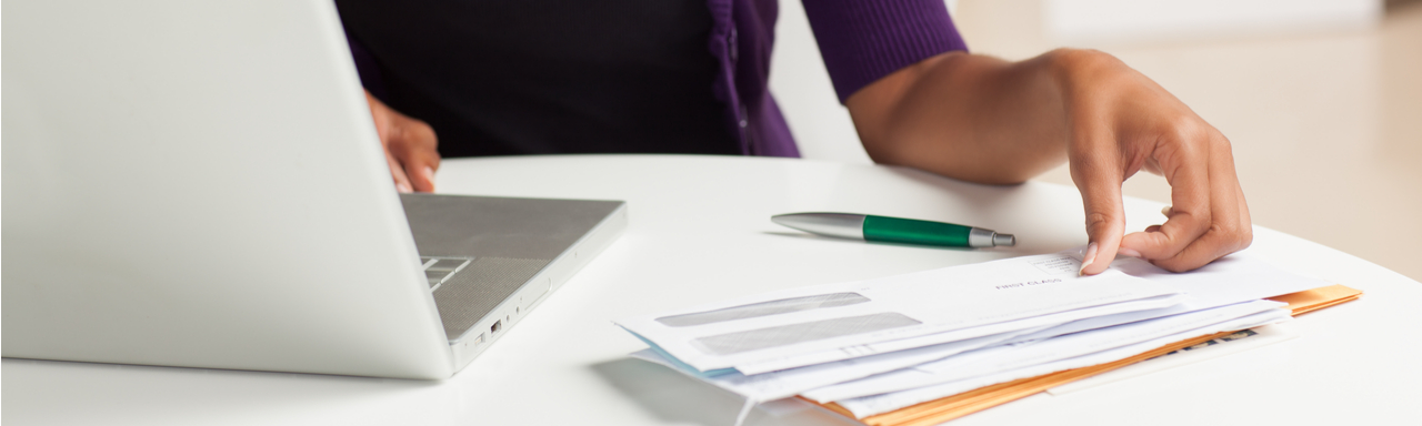 Woman reviewing bills and charges with laptop