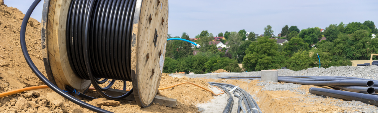 Rural broadband cables being laid on road beside trees