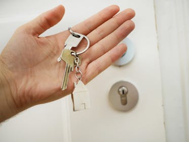 Holding house keys next to front door